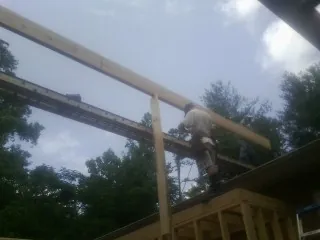 Carpenter setting a ridge beam over a new addition frame — Ice Dam Removal by Roofing Brothers in Cleburne